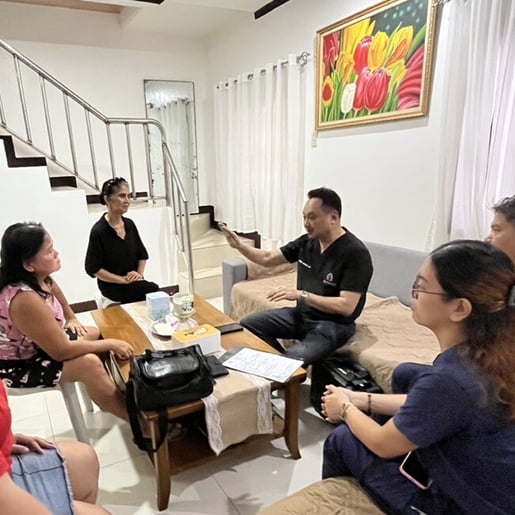 A doctor and a nurse meeting with a Filipino family
